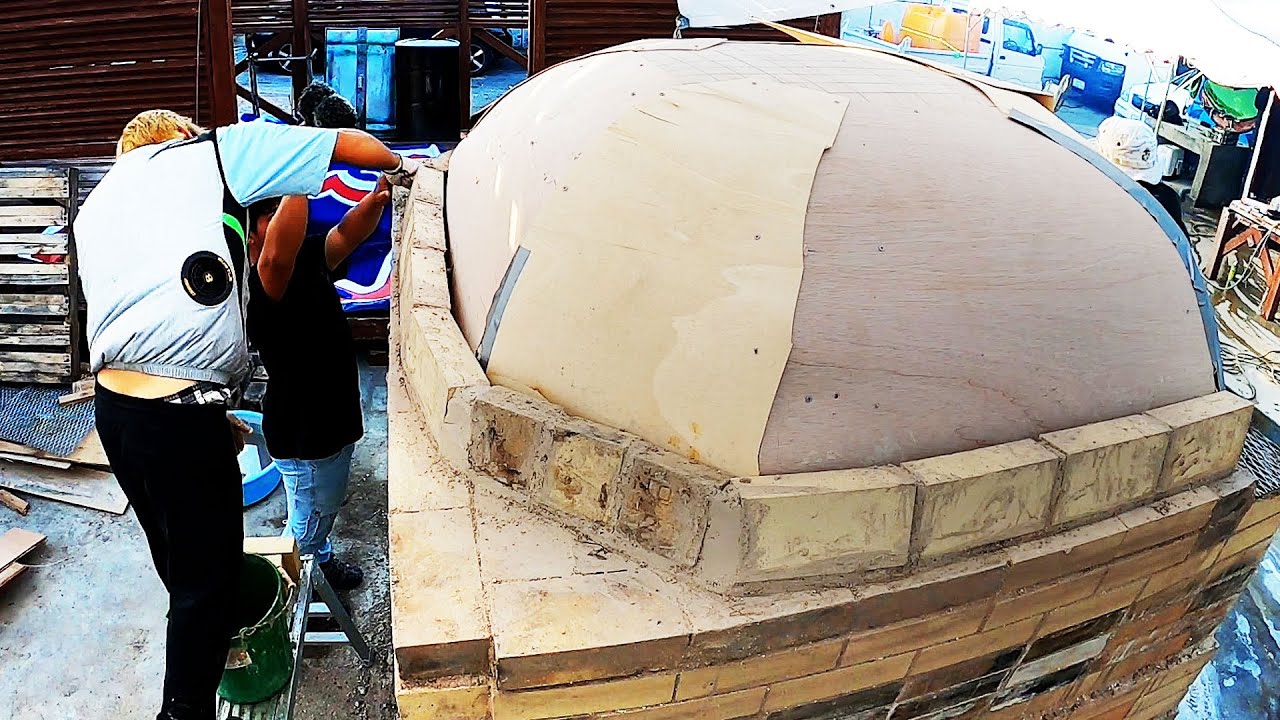 Curved brick construction of a giant dome-shaped pizza oven