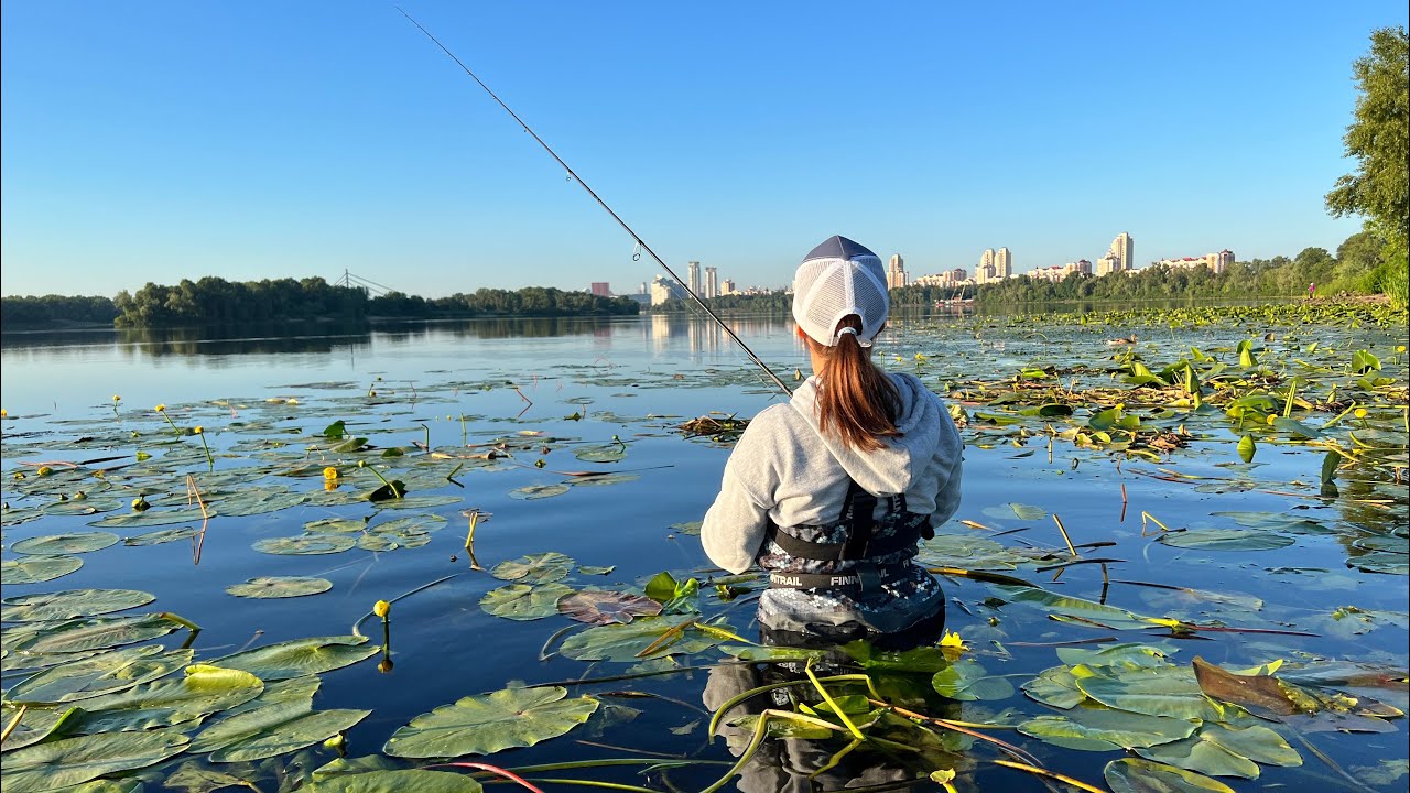 Риболовля на окуня по пояс в воді