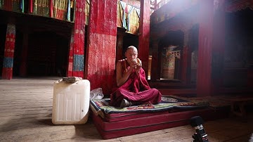 Monk at Lenggu Monastery blowing a conch shell horn