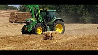 John Deere tractor collecting bales....