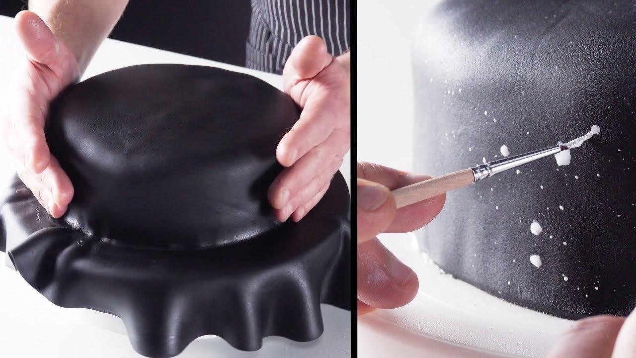 La torta viene avvolta in una copertura nera e dipinta. 
