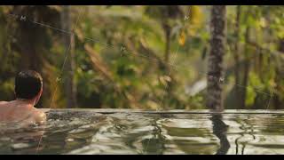 Rich Man Relaxation and Spending Time in a Tropical Open-air Infinity Swimming Pool During Summer