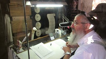 A Jewish scribe writes a Torah scroll in the ancient synagogue of Masada, Israel