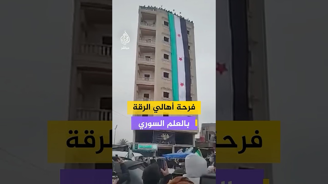 احتشاد عدد من أهالي مدينة الرقة في محيط دوار النعيم تزامنًا مع وضع علم الجمهورية العربية السورية