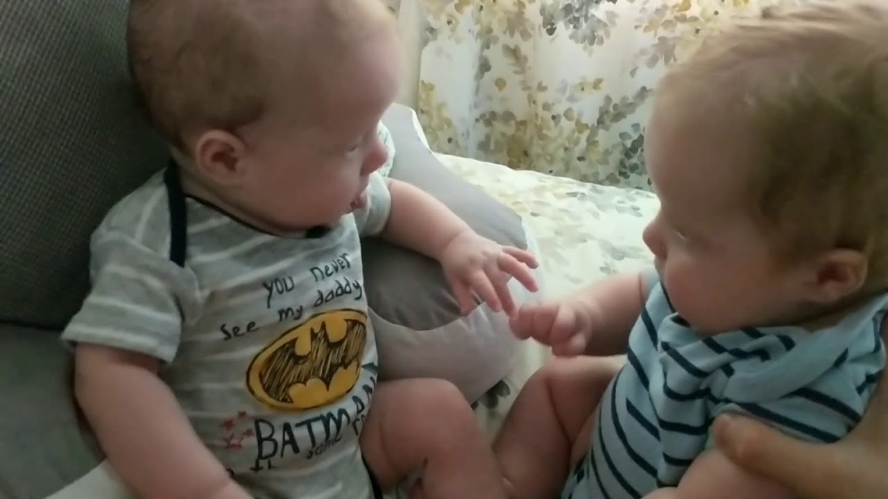 twin baby brothers hold hands on purpose for the first time