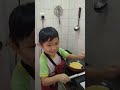 Chinese little boy cooking his lunch...