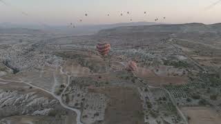 D-Log M. Goreme, Nevsehir, Turkey. Multicolored hot air balloons flying at dawn over Red Valley d...