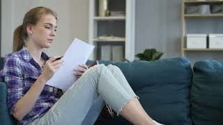Woman Reading Documents while Sitting on Couch Stock Footage - hive