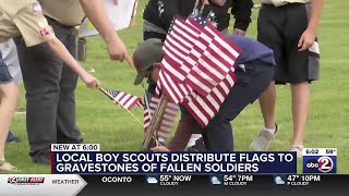 Local Boy Scouts place flags on the gravestones of fallen soldiers
