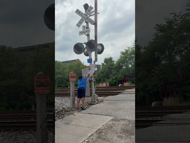 A Subway Train Passing The RailRoad Crossing Signs At The R/GS