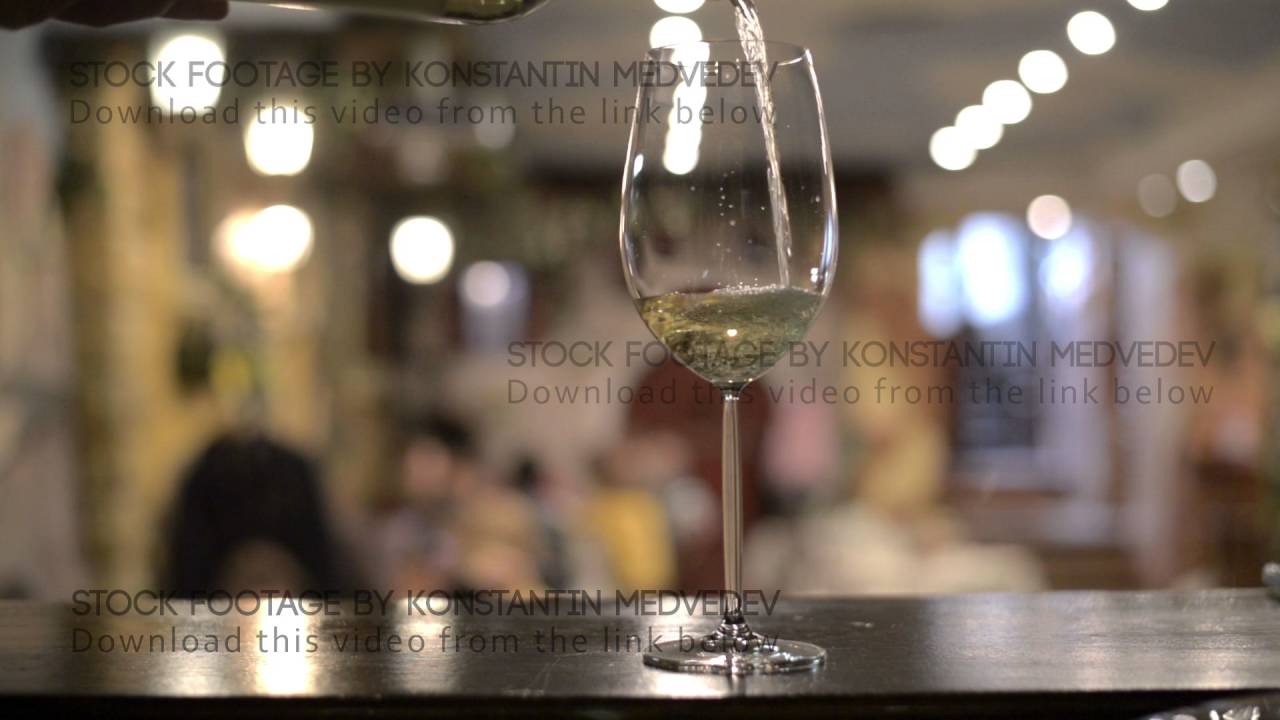 Close-up shot of wine pouring wine in glass against white background