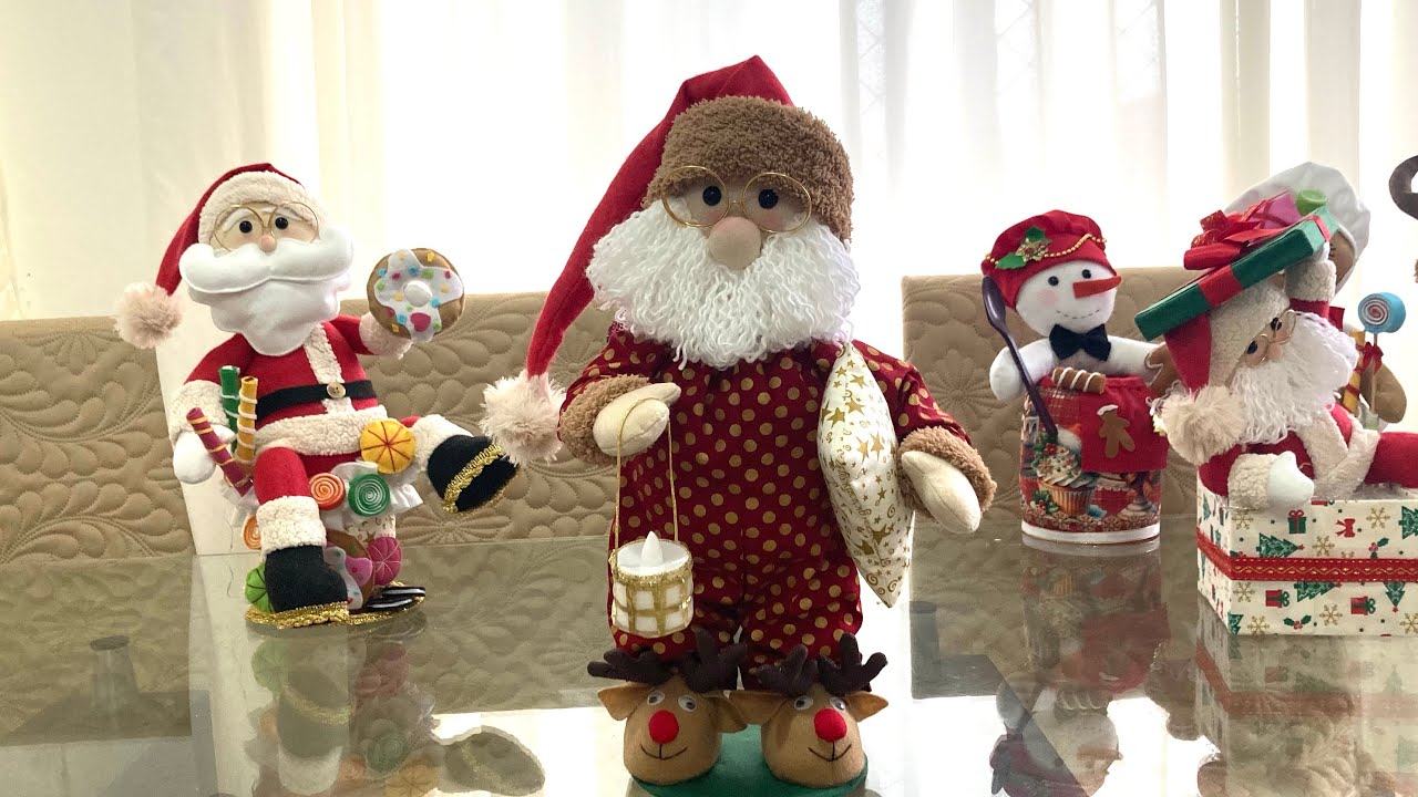 Papai Noel em pe segurando vela