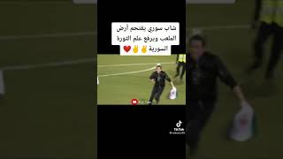 شاب سوري يقتحم الملعب ويرفع علم الثورة سوريا