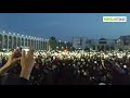 Митингующие на площади включили фонари на телефонах.