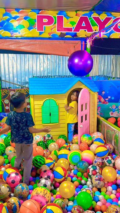 Melempar bola besar ungu ke atas rumah mini. Adiknya masuk rumah kurcaci mandi bola