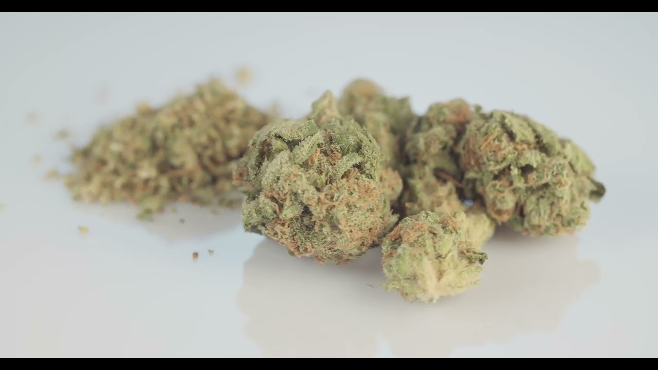 WHOLE CANNABIS BUD NEXT TO GROUND UP MARIJUANA 4K