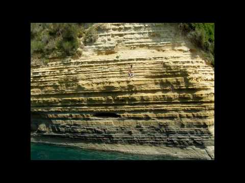 Crazy guy jumping off a cliff in Corfu Greece