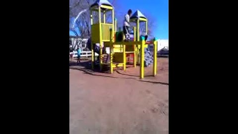 Friend doing a back flip off monkey bars