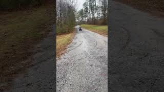 Boy on ATV rides down trail then goes down ledge hill and falls forward onto grass