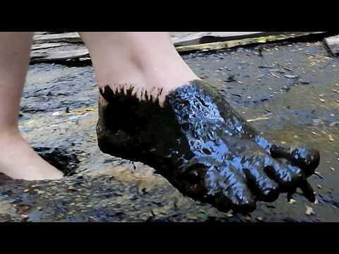 Girl walks barefoot through dirty deep mud
