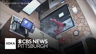 Video shows man hurling himself through door of restaurant before stealing cash