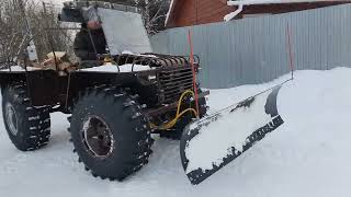 Вездеход ТОР-35 с отвалом чистит снег на дороге The TOR-35 all-terrain vehicle cleans snow on road.