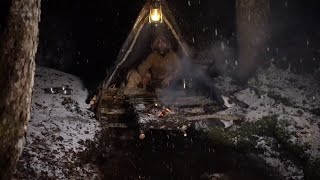 Survivor in the woods build a shelter over a creek . Heavy Snowstorm