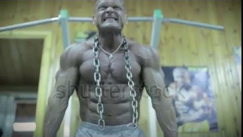 Stock Footage | Bodybuilder doing push-ups on exercise bars in the gym.
