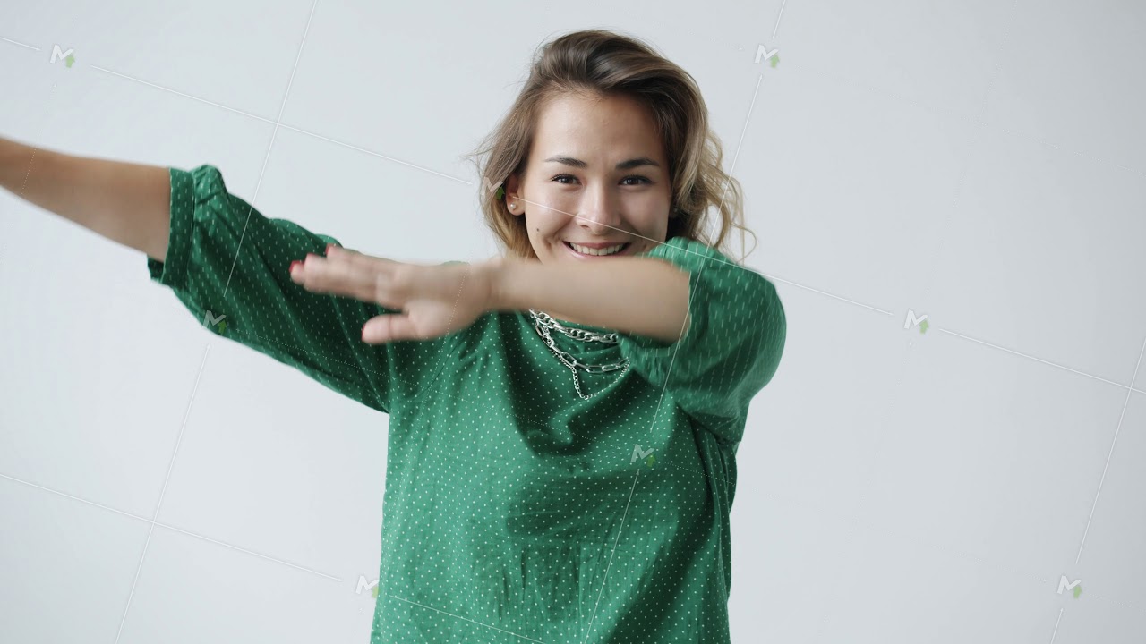 Slow motion portrait of cheerful young woman making dab dance movement smiling