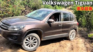 Красивая женщина водит Volkswagen Tiguan по бездорожью. Она красива и обладает хорошими навыками