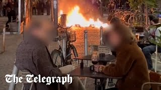France protests: Couple enjoy glass of wine metres from raging street fire in Bordeaux