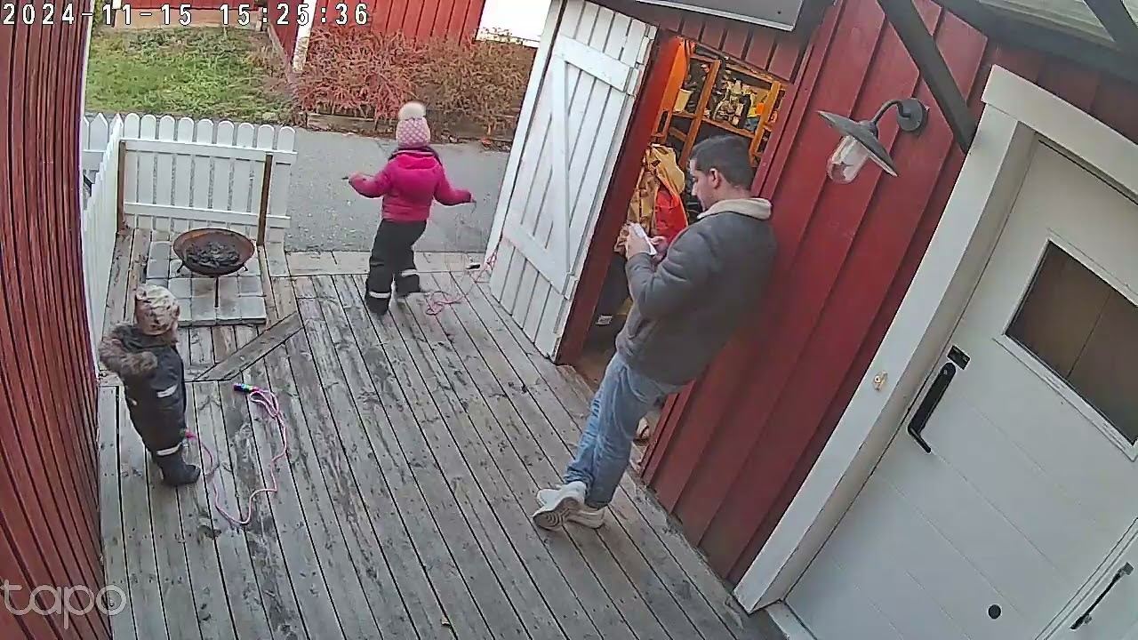 Girl throws football that bounces off Dad and roof and hits little boy on head (Security camera)