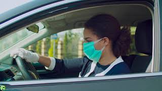 Female driver disinfecting steering wheel with hand sanitizer
