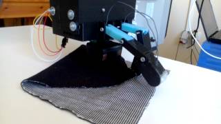 Underactuated robotic gripper - Unfolding a folded piece of fabric.