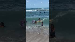 Surfer girl rides wave and accidentally rides over kid