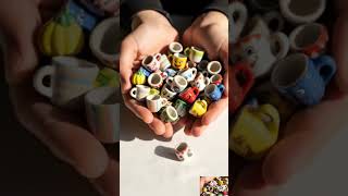 Macro ASMR video of tiny handmade ceramic mugs pouring slowly from cupped hands onto soft