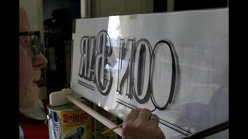 Signwriting the design in reverse on the back of the glass