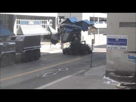 The filming of The Dark Knight Rises in downtown Pittsburgh on 8/12/2011. So far they have done about 6 different takes. Batman can be seen flying the plane.