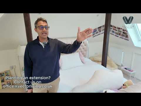 Bright guest bedroom from Vector Living’s loft extension in Teddington featuring skylight, dormer desk, and modern herringbone flooring.