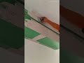 applying gypsum joint compound to the ceiling surface using a metal spatula to smooth the transition