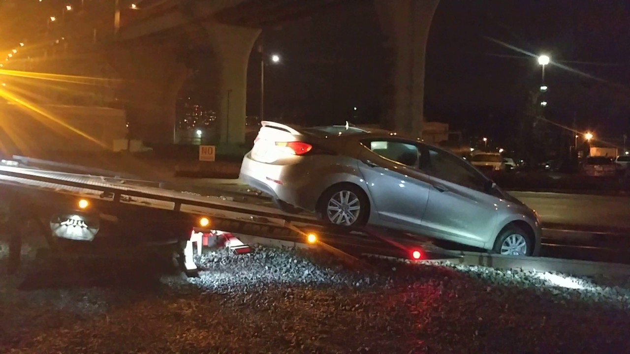 Car accident stuck on train tracks. Flatbed tow truck driver is a boss ...