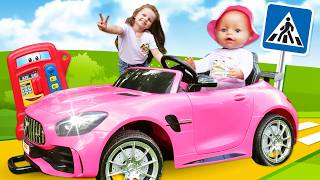 Maya and her baby doll are driving a toy car to their mom's picnic.