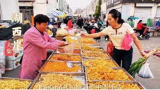 湖西崖大集 错综复杂的市场街道里人潮涌动 老八碗当街售卖 大米板正当时令  熬糖的香气满溢老街 叫卖的喊声此起彼伏 巨大的土豆价格低廉 超多的零食琳琅满目 曾经的农村集市进入市场 成为人们购物首选之地