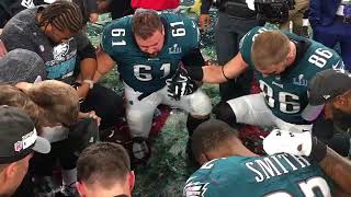 Philadelphia Eagles players come together to pray after winning the Super Bowl