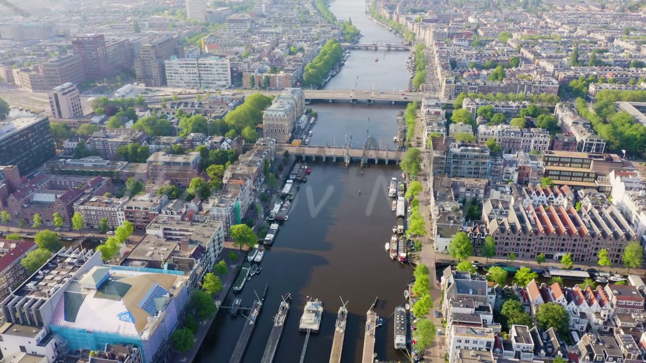 Amsterdam, Netherlands. Flying over the city rooftops. Amstel River, Amstel Gateways, Aerial View