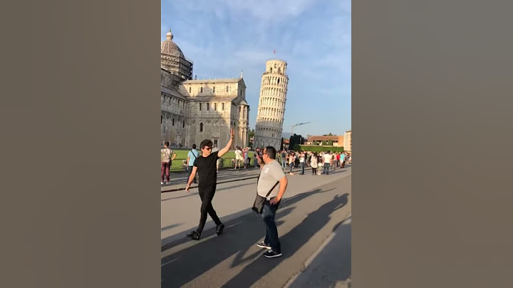 Teenager High Fives A Stranger As He Is Posing To Take The Classic Leaning Tower of Pisa picture