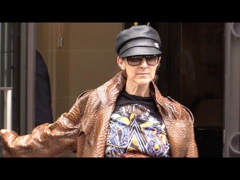 Celine Dion signs a portrait painting from a fan outside of her hotel in Paris