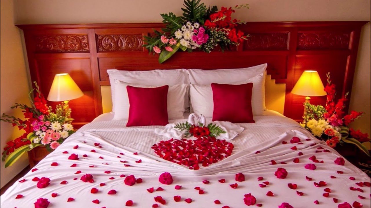 Home romance. Спальня для молодоженов. Кровать для молодоженов. Лепестки роз на кровати. Романтическая обстановка.