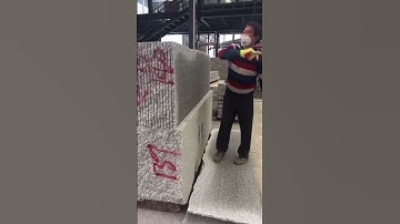Worker splitting stone slabs with simple tool