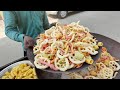 Street cart vendor making colorful fryums in sand  amazing street food of india